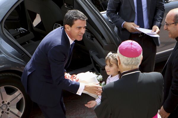 رئيس الوزراء الفرنسي مانويل فالس  أثناء زيارته للكنيسة الكاثوليكية الرومانية التي تضم أسر اللاجئين العراقيين في عمان، الأردن  12 أكتوبر/ تشرين الأول 2015 - سبوتنيك عربي