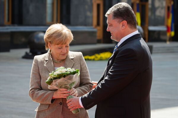 الرئيس الأوكراني بيوتر بوروشينكو يهدي باقة من الأزهار لمستشارة ألمانيا أنجيلا ميركل خلال زيارتها إلى كييف، أوكرانيا 2014 - سبوتنيك عربي
