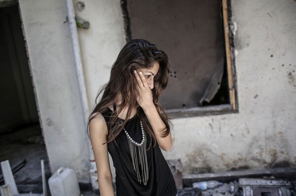 فتاة تتفقد منزلها وسط الركام في مدنية حمص، بعد أن تركته نتيجة العمليات العسكرية - سبوتنيك عربي