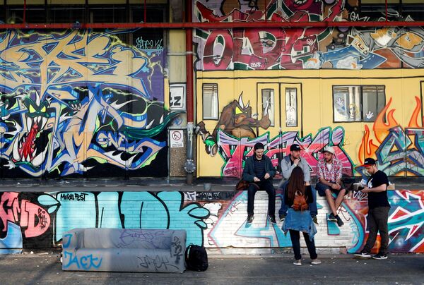 رسم غرافيتي على جدران مصنع قديم لصنع السجائر، كجزء من مهرجان برلين للجداريات 2018 الأول من نوعه، حيث يقوم الفنانون المدنيون المحليون والدوليون بإنشاء معرض كبير في الهواء الطلق لإثراء المساحات الحضرية في برلين، ألمانيا 21 مايو/ أيار 2018 - سبوتنيك عربي