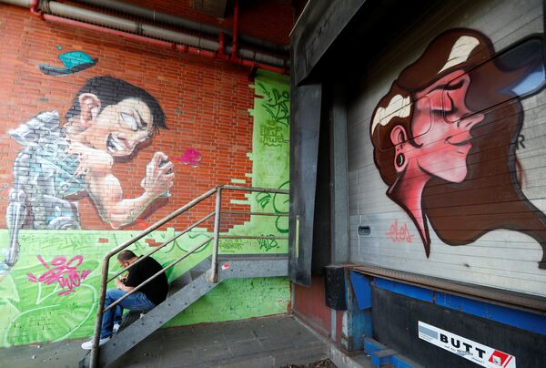 رسم غرافيتي على جدران مصنع قديم لصنع السجائر، كجزء من مهرجان برلين للجداريات 2018 الأول من نوعه، حيث يقوم الفنانون المدنيون المحليون والدوليون بإنشاء معرض كبير في الهواء الطلق لإثراء المساحات الحضرية في برلين، ألمانيا  21 مايو/ أيار 2018 - سبوتنيك عربي