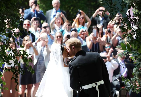 قبلة الأمير هاري لميغان ماركل على مدخل كنيسة القديس جورج في ويندسور كاست، بريطانيا 19 مايو/ أيار 2018 - سبوتنيك عربي