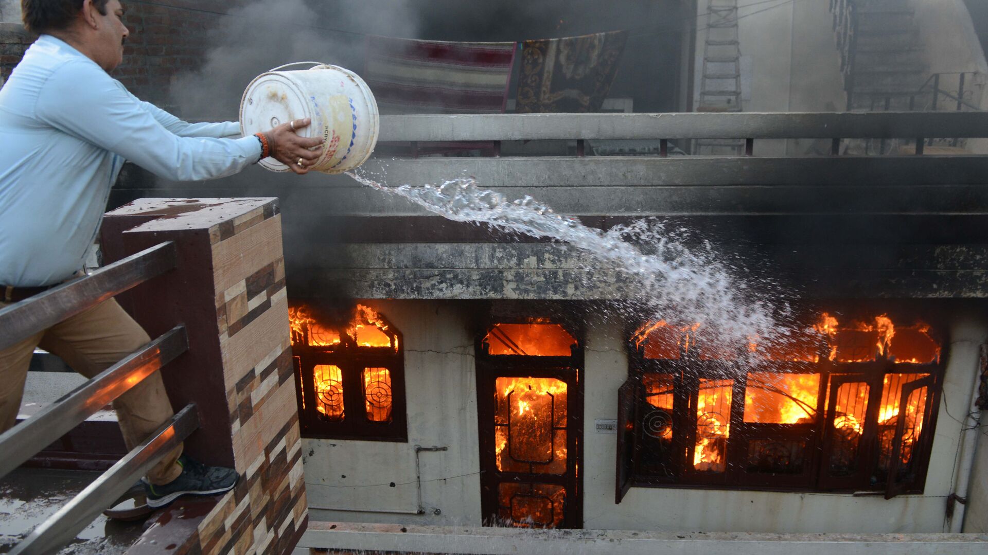 أحد السكان يحاول إخماد حريق في متجر كهربائي في أمريتسار، الهند في 20 مايو/ أيار 2018 - سبوتنيك عربي, 1920, 23.04.2021