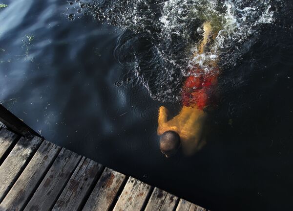 رجل يسبح في مياه النهر بمنطقة ستروغينو بموسكو - سبوتنيك عربي