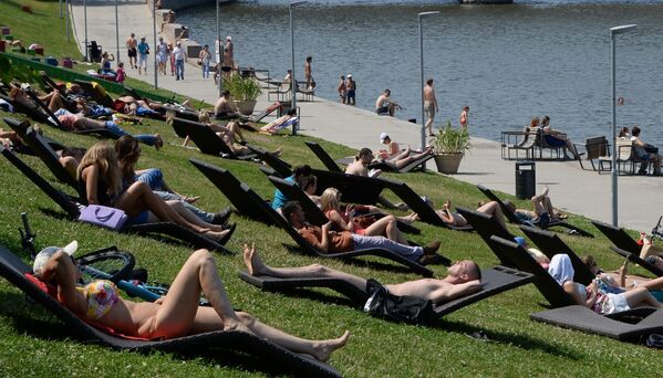 سكان موسكو في يوم العطلة يستمتعون بحمام شمسي في منطقة فوروبيوفي غوري (تل الدويري) - سبوتنيك عربي