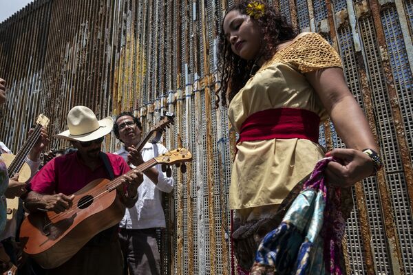 موسيقيون وراقصون في فعالية فاندانغو فرونتيريزو (Fandango Fronterizo) السنوية، في متنزه الصداقة على الحدود بين الولايات المتحدة والمكسيك في بلاياس دي تيخوانا، ولاية باجا كاليفورنيا، شمال غرب المكسيك، في 26 مايو/ أيار 2018 - سبوتنيك عربي
