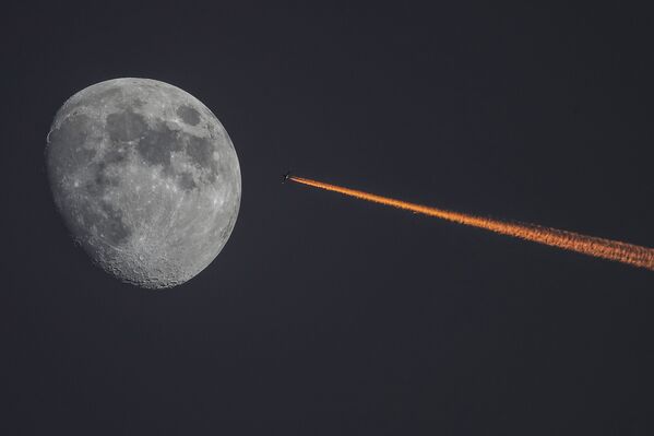 القمر وطائرة على خلفية غروب الشمس - سبوتنيك عربي
