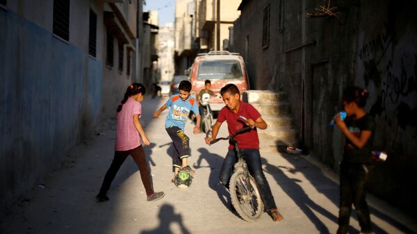 أطفال فلسطينيون يلعبون الكرة في أحد شوارع مخيم البقعة بالقرب من عمان، الأردن 29 مايو/ أيار 2018 - سبوتنيك عربي