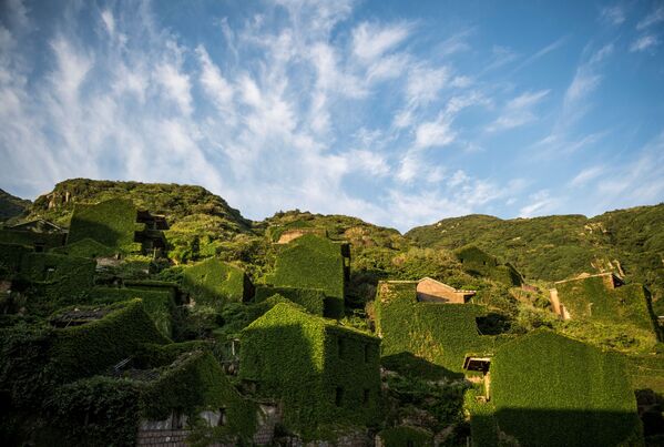منازل مهجورة مغطاة بالنباتات الكثيفة في قرية هوتوان على جزيرة شينغشان بإقليم تشيجيانغ الشرقي الصيني، 31 مايو/ أيار 2018 - سبوتنيك عربي