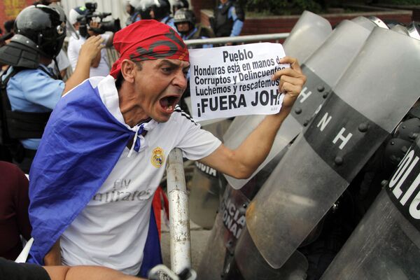 أحد المتظاهرين يحمل لافتة مكتوب عليها بالإسبانية: هندوراس في أيدي الفاسدين والجنائيين. سنقاتل وننقذها! خلال احتجاج في تيغوسيغالبا، هندوراس، 2 يونيو/ حزيران 2018 - سبوتنيك عربي