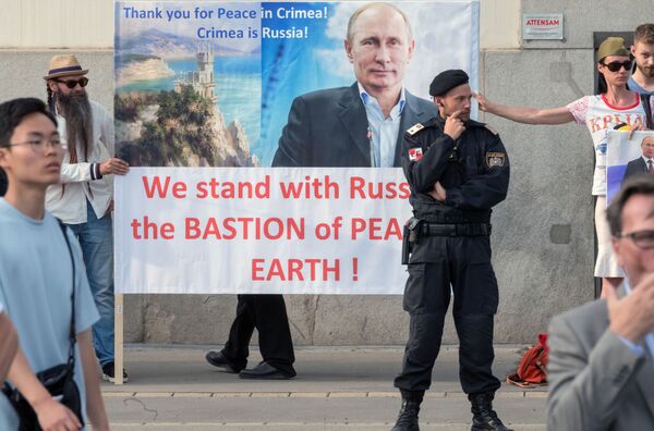 مواطنون من النمسا يحملون ملصقات تحمل صورة الرئيس الروسي فلاديمير بوتين مكتوب عليها شكرا للسلام في القرم! خلال اجتماعه مع الرئيس الاتحادي النمساوي ألكسندر فان دير بيلين في قصر هوفبورغ في فيينا - سبوتنيك عربي