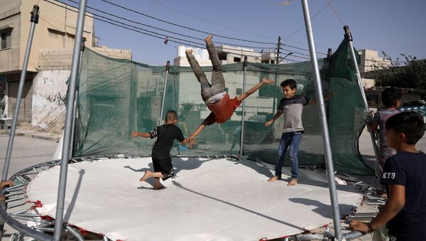 أطفال يلعبون الترامبولين في العاصمة الأردنية عمان - سبوتنيك عربي
