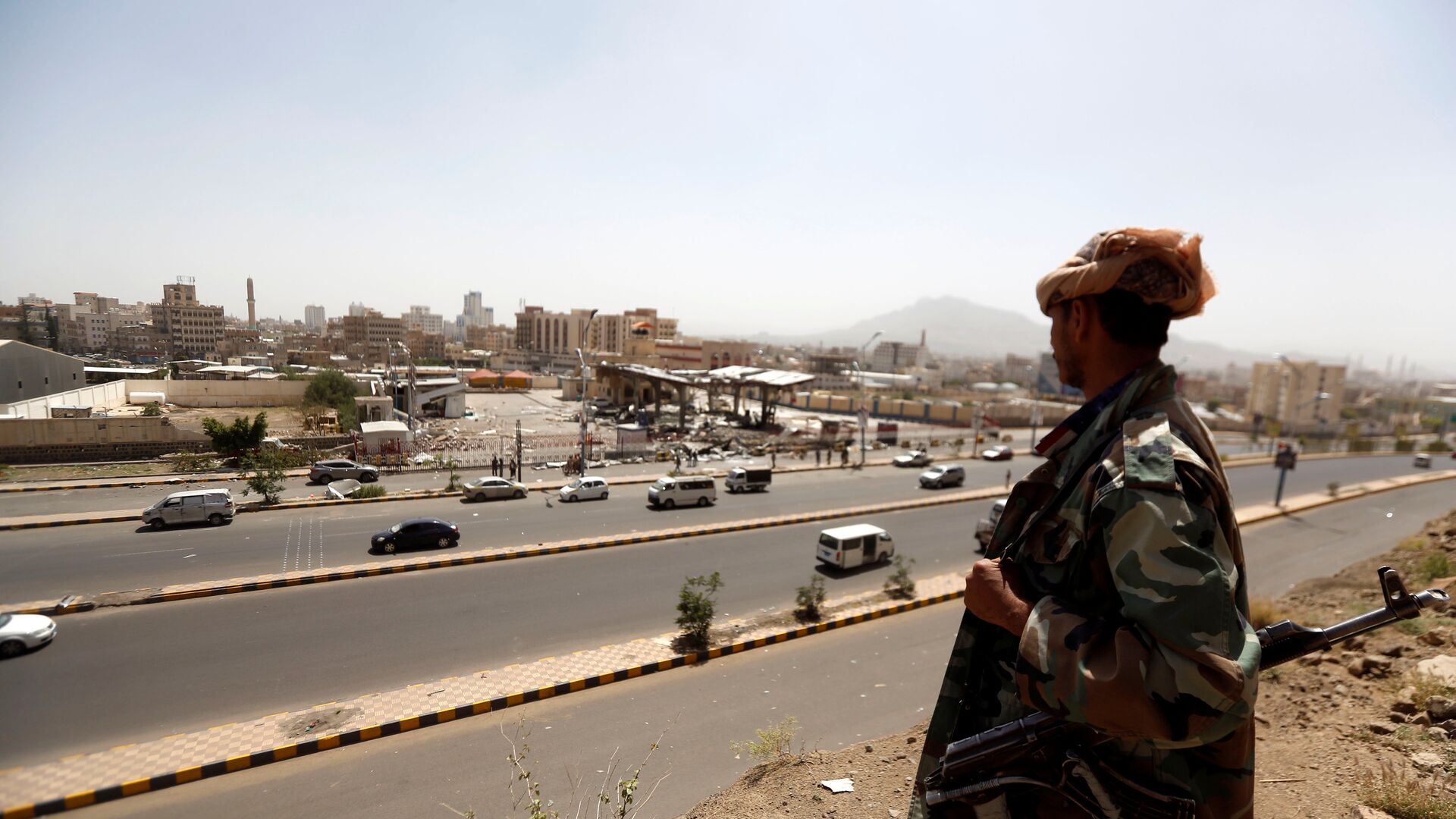 جندي يمني يقف أمام محطة وقود تعرضت للقصف في العاصمة صنعاء في اليمن - سبوتنيك عربي, 1920, 31.10.2021