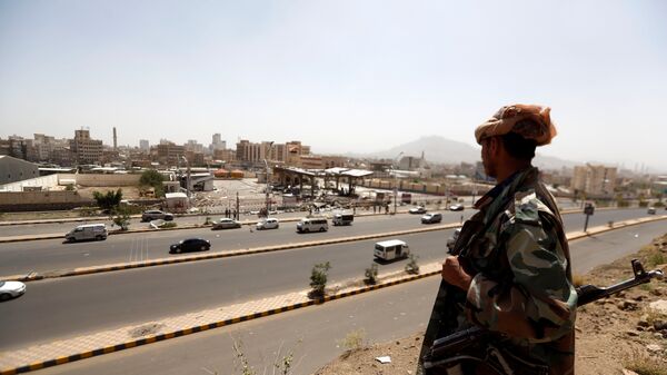 جندي يمني يقف أمام محطة وقود تعرضت للقصف في العاصمة صنعاء في اليمن - سبوتنيك عربي