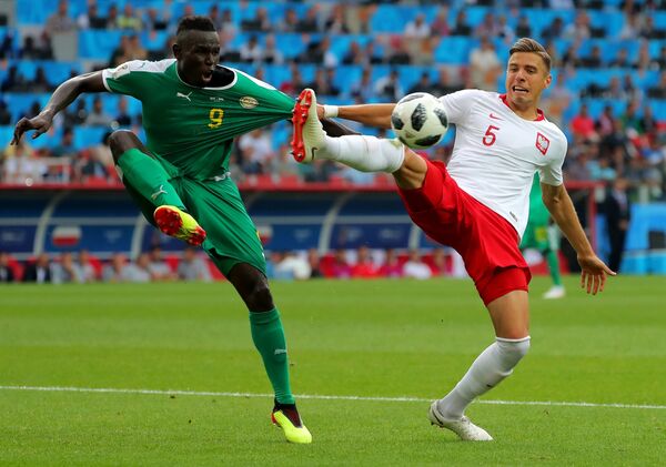 اللاعب السنغالي مامي بيرام ديوف واللاعب البولندي يان بيدناريك في المباراة التي جمعت فريقهما - سبوتنيك عربي