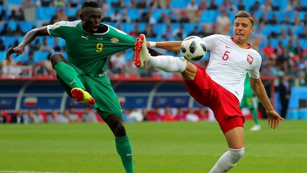 اللاعب السنغالي مامي بيرام ديوف واللاعب البولندي يان بيدناريك في المباراة التي جمعت فريقهما - سبوتنيك عربي