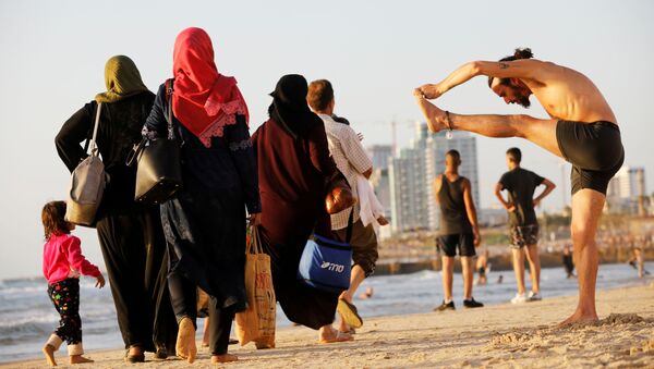 تجول الناس على شاطئ البحر في تل أبيب خلال عطلة عيد الفطر - سبوتنيك عربي