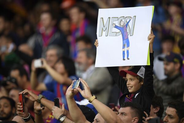 صبي يحمل لافتة للاعب فريق برشلونة والمنتخب الأرجنتيني ليونيل ميسي - سبوتنيك عربي