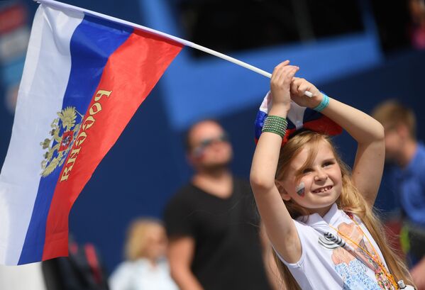 مشجعة صغيرة ترفع علم روسيا خلال تشجيعها للمنتخب الروسي في مباراة مرحلة المجموعة روسيا وأورغواي، 2018 - سبوتنيك عربي