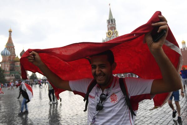 مشجع المنتخب المغربي يختبئ بالعلم من المطر على الساحة الحمراء في موسكو، 2018 - سبوتنيك عربي