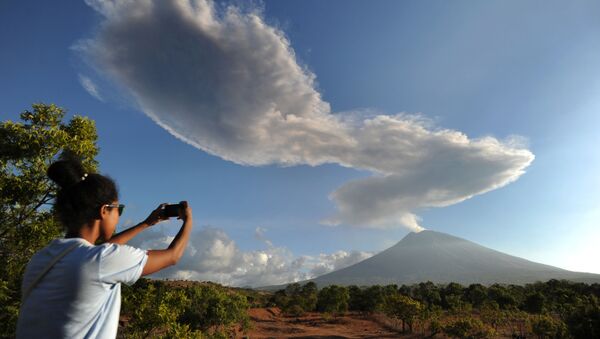 امرأة تلتقط صورة لبركان ماونت أغاونغ في جزيرة بالي، إندونيسيا 5 يوليو/ تموز 2018 - سبوتنيك عربي