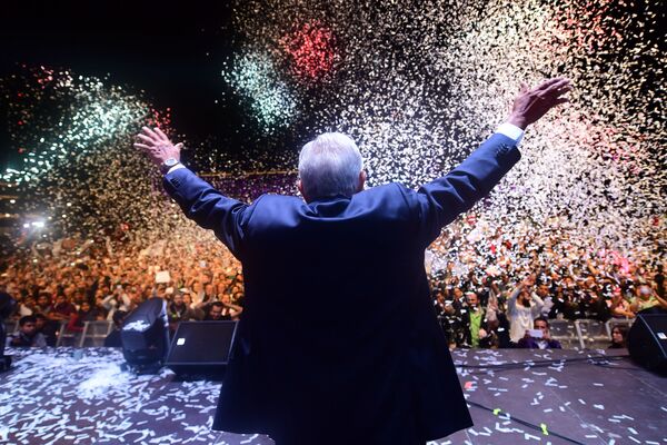 رئيس المكسيك المنتخب حديثًا أندريس مانويل لوبيز أوبرادور، مرشح من حزب جونتوس هاريمو هيستوريا، يحي مؤيديه في ساحة زوكالو بعد فوزه في الانتخابات العامة، في مكسيكو سيتي، في 1 يوليو/ تموز 2018 - سبوتنيك عربي
