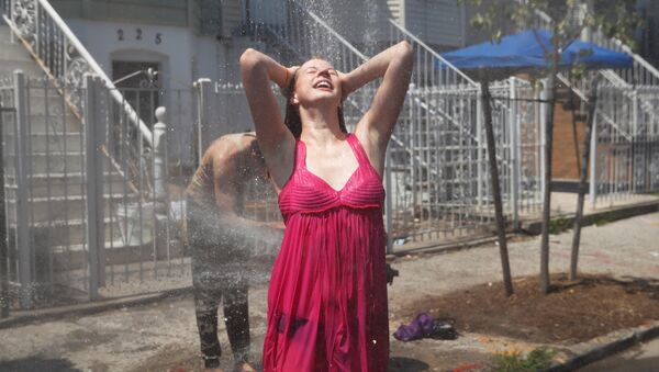إمرأة تنتعش بالماء وسط حرارة الصيف - سبوتنيك عربي