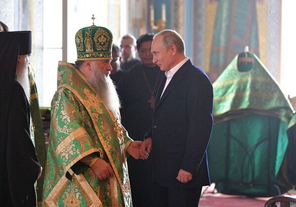 الرئيس فلاديمير بوتين ورئيس دير فلاديكا، خلال زيارة الرئيس إلى دير التجلي لإحياء مراسم كنسية - سبوتنيك عربي