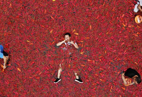 أحد المشاركين في مسابقة أكل الفلفل الأحمر الحار (تشيلي) في مدينة تشونغ كينغ بمقاطعة هونان، الصين 8 يوليو/ تموز 2018 - سبوتنيك عربي