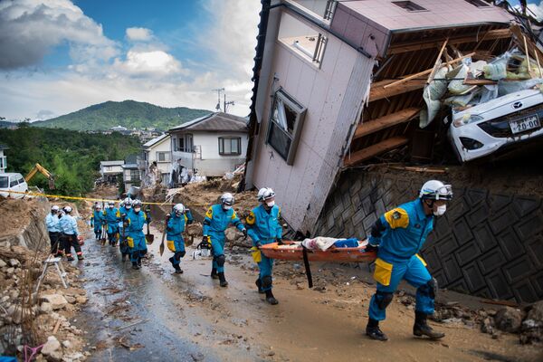 وصول طواقم الإنقاذ ورجال الشرطة لإتمام عمليات الإنقاذ في منطقة كومانو، هيروشيما، اليابان 9 يوليو/ تموز 2018 - سبوتنيك عربي