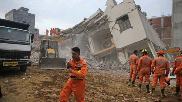 عمال الإنقاذ يعملون في موقع مبنى انهار في قرية شاهبيري، شرق نيودلهي، الهند  18 يوليو ، 2018 - سبوتنيك عربي