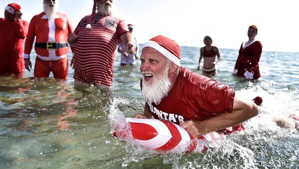 أشخاص يرتدون زي بابا نويل يشاركون في مسابقة للسباحة  سانتا كلوز العالمي على شاطئ بيليفو بالقرب من كوبنهاجن، كلامنبورغ، الدنمارك 24 يوليو/ تموز 2018 - سبوتنيك عربي