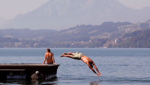 رجل يقفز الرجل في بحيرة زوغ في سويسرا هربا من حر الصيف - سبوتنيك عربي