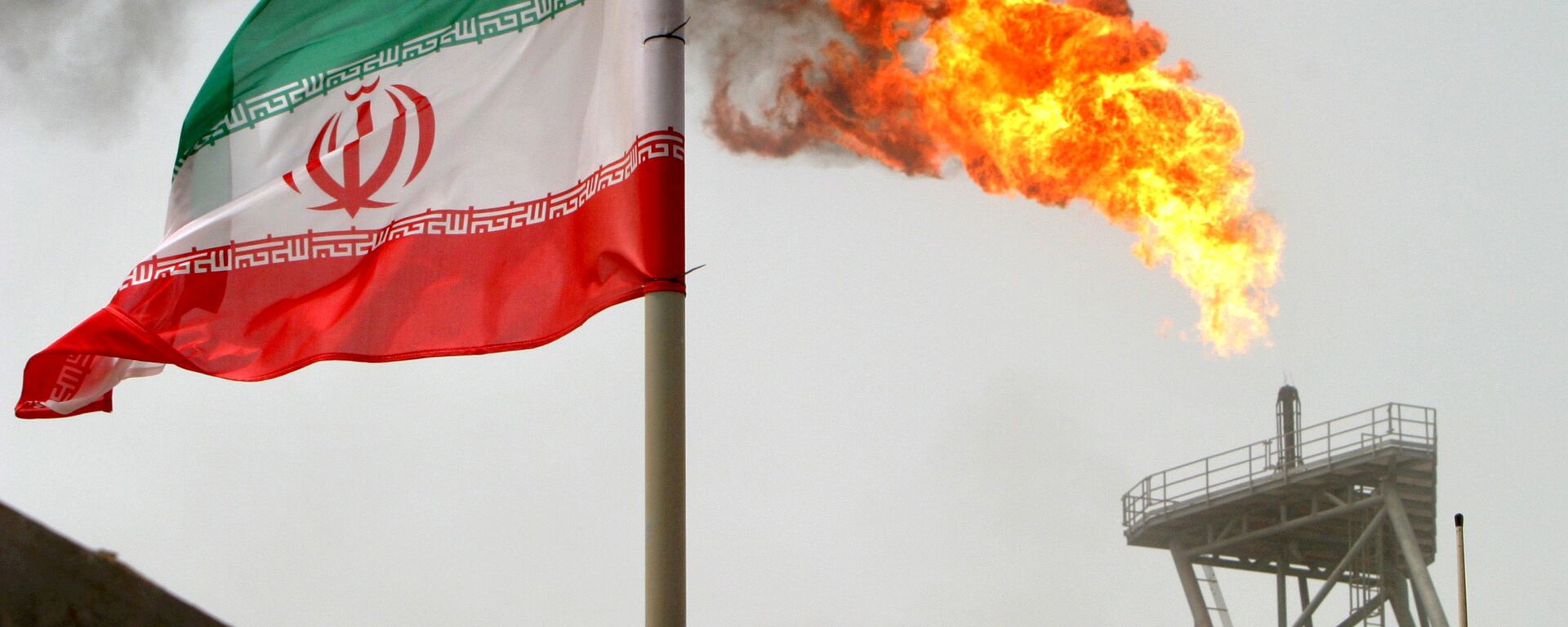 علم إيران على خلفية توهج ناري لغاز في حقل سوروش النفطي في الخليج الفارسي، إيران 25 يوليو/ تموز 2018 - سبوتنيك عربي, 1920, 22.11.2018