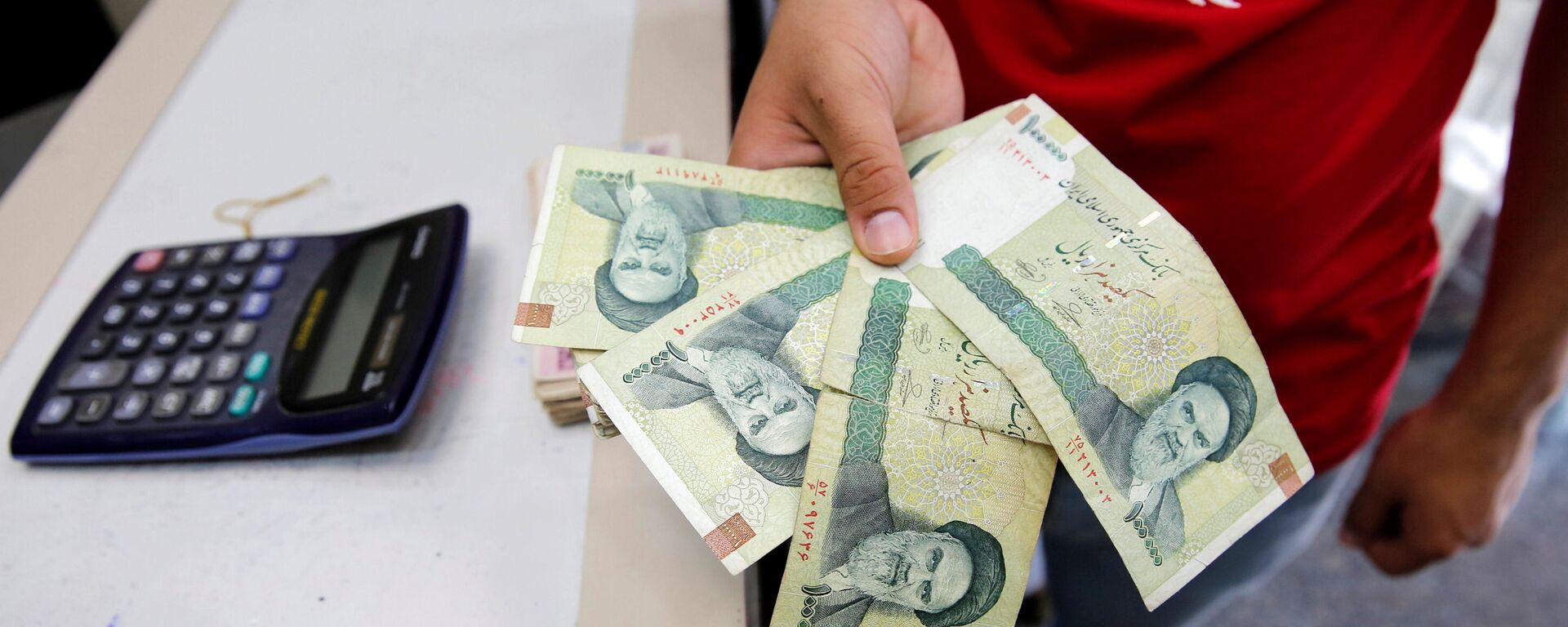 بائع يتفقد الريال الإيراني في محل لبيع العملات في بغداد ، العراق 8 أغسطس/ آب 2018 - سبوتنيك عربي, 1920, 04.12.2021