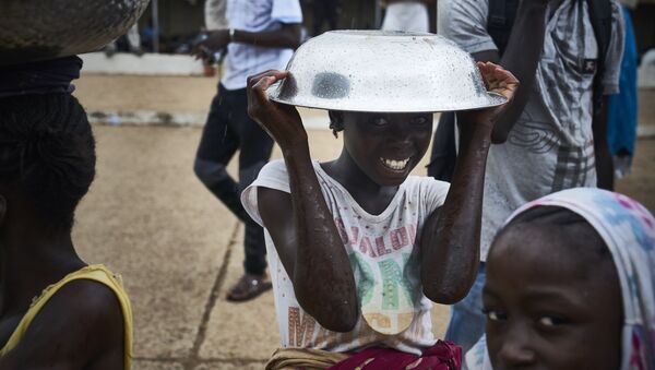 فتاة تقف مع وعاء معدني فوق رأسها على هامش احتجاجات ضد الرئيس المالي الحالي في باماكو في 11 أغسطس/ آب2018 ، عشية الجولة الثانية من الانتخابات الرئاسية في مالي. - سبوتنيك عربي