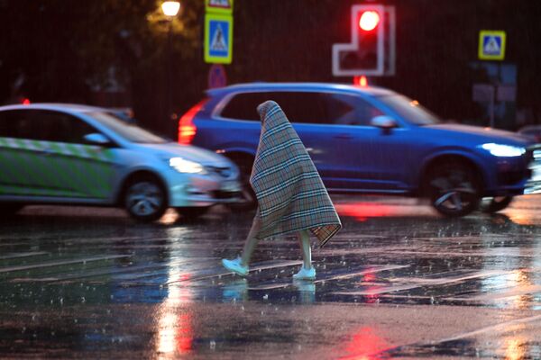أحد المارة خلال الأمطار الغزيرة في موسكو - سبوتنيك عربي