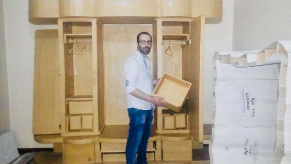 الشاب وسيم نحاس (25 عاماً)،موظف في شركة خاصة بمدينة حلب من صناعة غرفة نوم من النفايات الكرتونية - سبوتنيك عربي