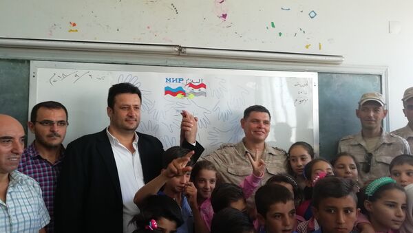 جنرال روسي وضباطه يشاركون أطفال قمحانة السورية يومهم الدراسي الأول - سبوتنيك عربي