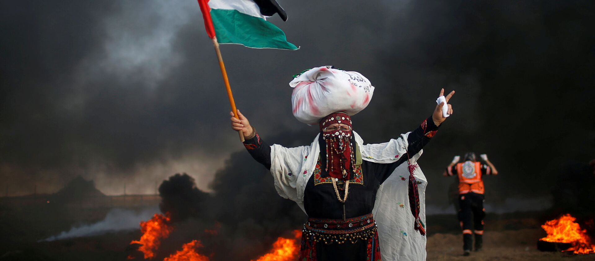امرأة تحمل علم فلسطين خلال احتجاجات تدعو لرفع الحصار الإسرائيلي عن قطاع غزة، والمطالبة بحق العودة، على الحدود بين القطاع وإسرائيل، شرق مدينة غزة، 14 سبتمبر/ أيلول 2018 - سبوتنيك عربي, 1920, 02.11.2021