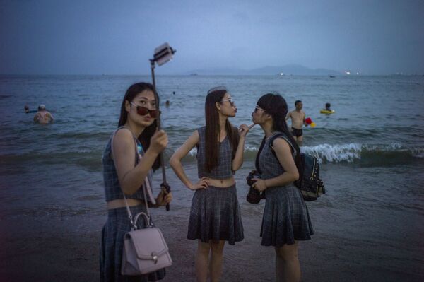 فتيات يلتقطن صور سيلفي على شاطئ بمدينة كينجداو، الصين - سبوتنيك عربي