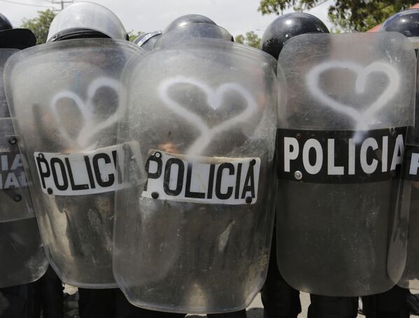 نشطاء يرسمون رأس قلب على دروع شرطة الشغب في ماناغوا، خلال احتجاجات ضد سياسة رئيس نيكاراغوا دانييل أورتيغا، 23 سبتمبر/ أيلول 2018 - سبوتنيك عربي