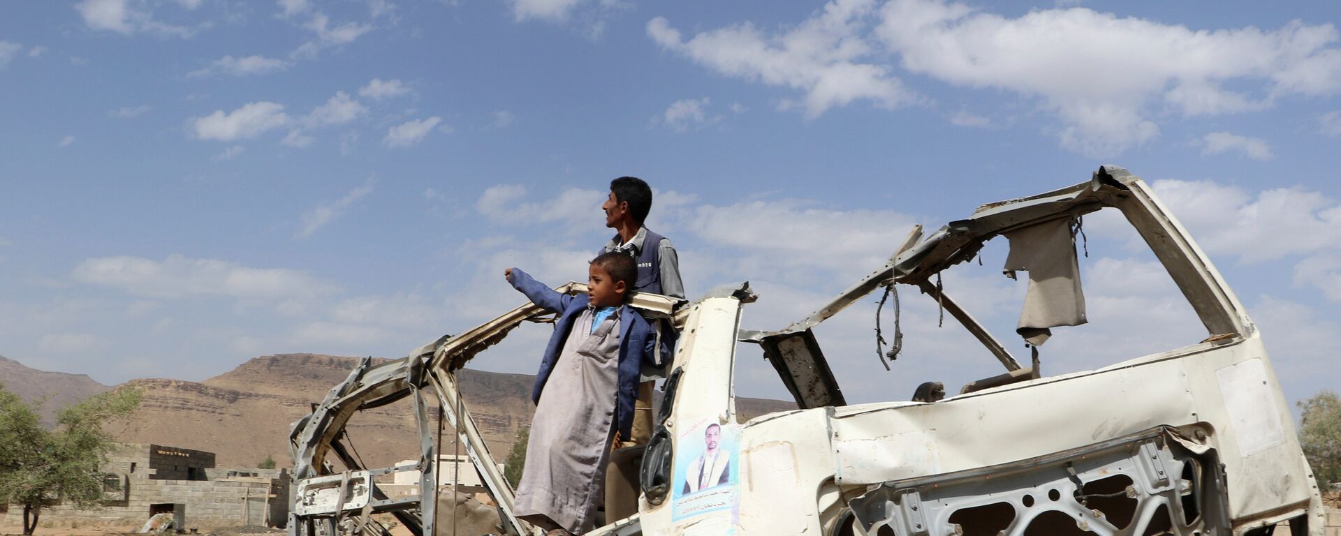 أطفال يقفون على حافلة تعرضت للدمار في صعدة - اليمن  - سبوتنيك عربي, 1920, 19.03.2022
