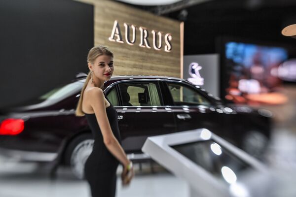 فتاة تقف أمام سيارة Aurus Senat في المعرض الدولي للسيارات لعام 2018 - سبوتنيك عربي