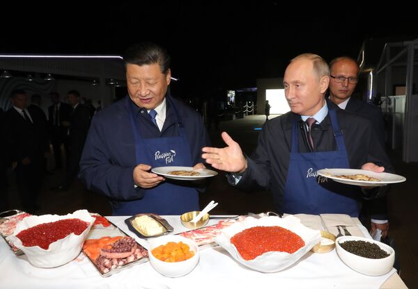 الرئيسان الروسي فلاديمير بوتين ونظيره الصيني يطهوان الفطائر المحلاة في إطار منتدى الشرق الاقتصادي في فلاديفوستوك - سبوتنيك عربي