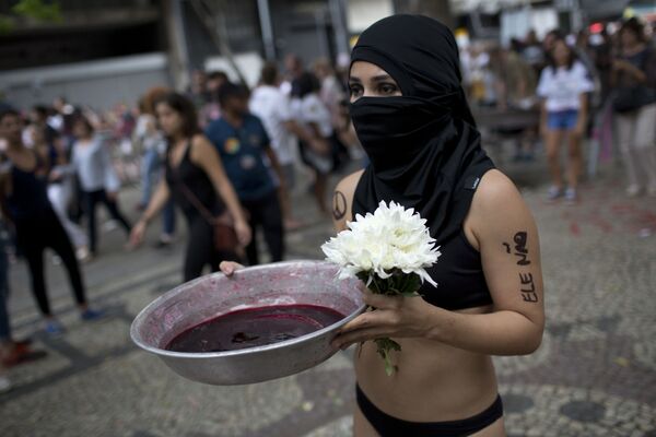 امرأة تحمل صحنا من الحبر الأحمر، حيث يرمز إلى إراقة الدماء التي ستحدث إذا تم انتخابات يائير بولسونارو، المرشح الرئيسي للانتخابات الرئاسية، أثناء احتجاجات ضد بولسونارو في ريو دي جانيرو، البرازيل، 29 سبتمبر/ أيلول 2018 - سبوتنيك عربي