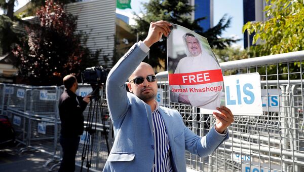 متظاهر يحمل صورة للصحفي السعودي جمال خاشقجي أثناء احتجاج أمام القنصلية السعودية في إسطنبول - سبوتنيك عربي
