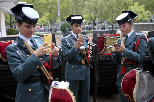 ضابطات حرس المدنية النسائية يتفقدن هواتفهن المحمولة، وفي انتظار بدء العرض العسكري بمناسبة الاحتفال باليوم الوطني في مدريد، إسبانيا، 12 أكتوبر/ تشرين الأول 2018 - سبوتنيك عربي