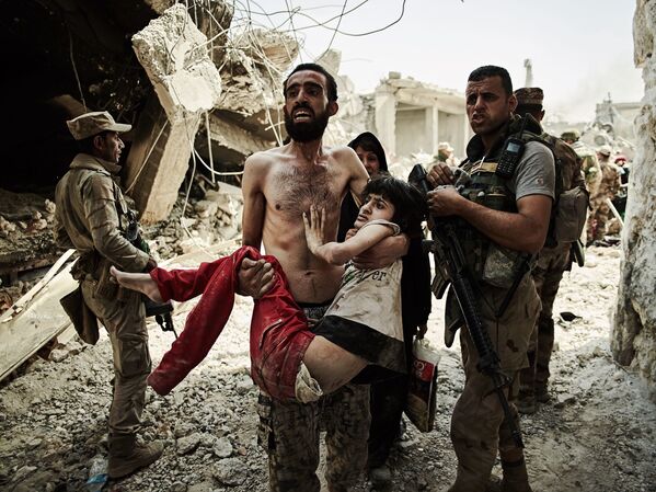 صورة بعنوان Man carries injured son، للمصور زاخ لوري، الحاصل على المرتبة الأولى في فئة رحلات ومغامرات - سبوتنيك عربي