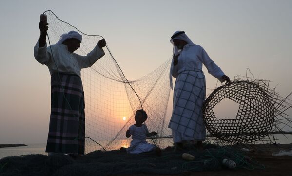 رجال إمارتيون يدربون طفلا على الحرف الصناعية اليدوية خلال مهرجان دلما البحري في الخريج العربي، 40 كم عن أبو ظبي، الإمارات المتحدة 27 أكتوبر/ تشرين الأول 2018 - سبوتنيك عربي